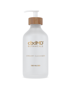 CBD Creamy Cleanser: An elegant dance of purity captured in a glass bottle with gold script and a glossy white pump, a poetic elixir for your skin.